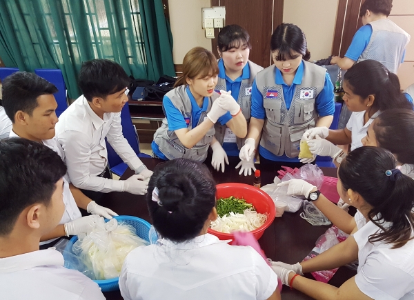 지난달 16일, 순천향대 봉사단원 학생들이 캄보디아 시엠립 BBU(Build Bright University) 한국어 교양과목 수강 대학생들을 대상으로 캄보디아에서 선호하는 한국음식 1위인 “김치”를 직접 만들어보는 프로그램에 참여해 설명을 듣고 있다.[출처:순천향대]
