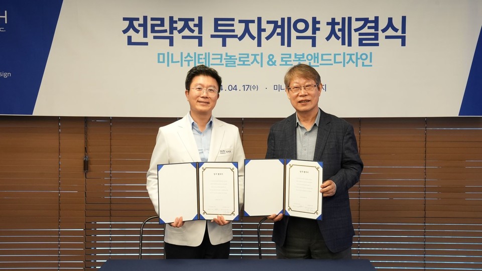 (왼쪽부터)강정호 미니쉬테크놀로지 대표와 김진오 로봇앤드디자인 회장이 투자계약서에 서명한 뒤 기념촬영을 하고 있다(사진=미니쉬테크놀로지)